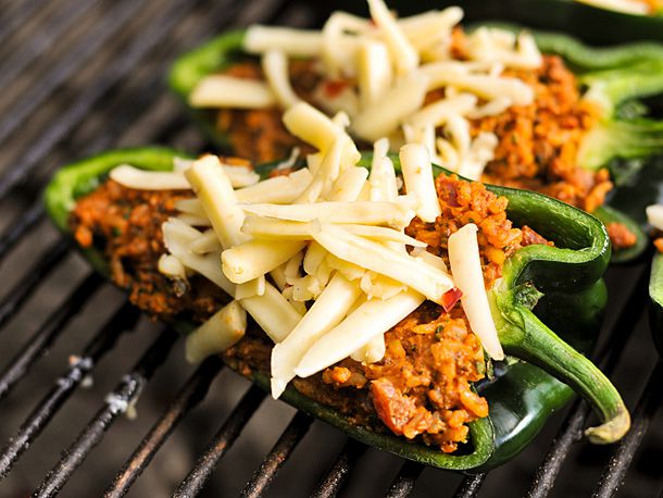 Stuffed poblano pepper topped with pepper jack cheese on the grill. 