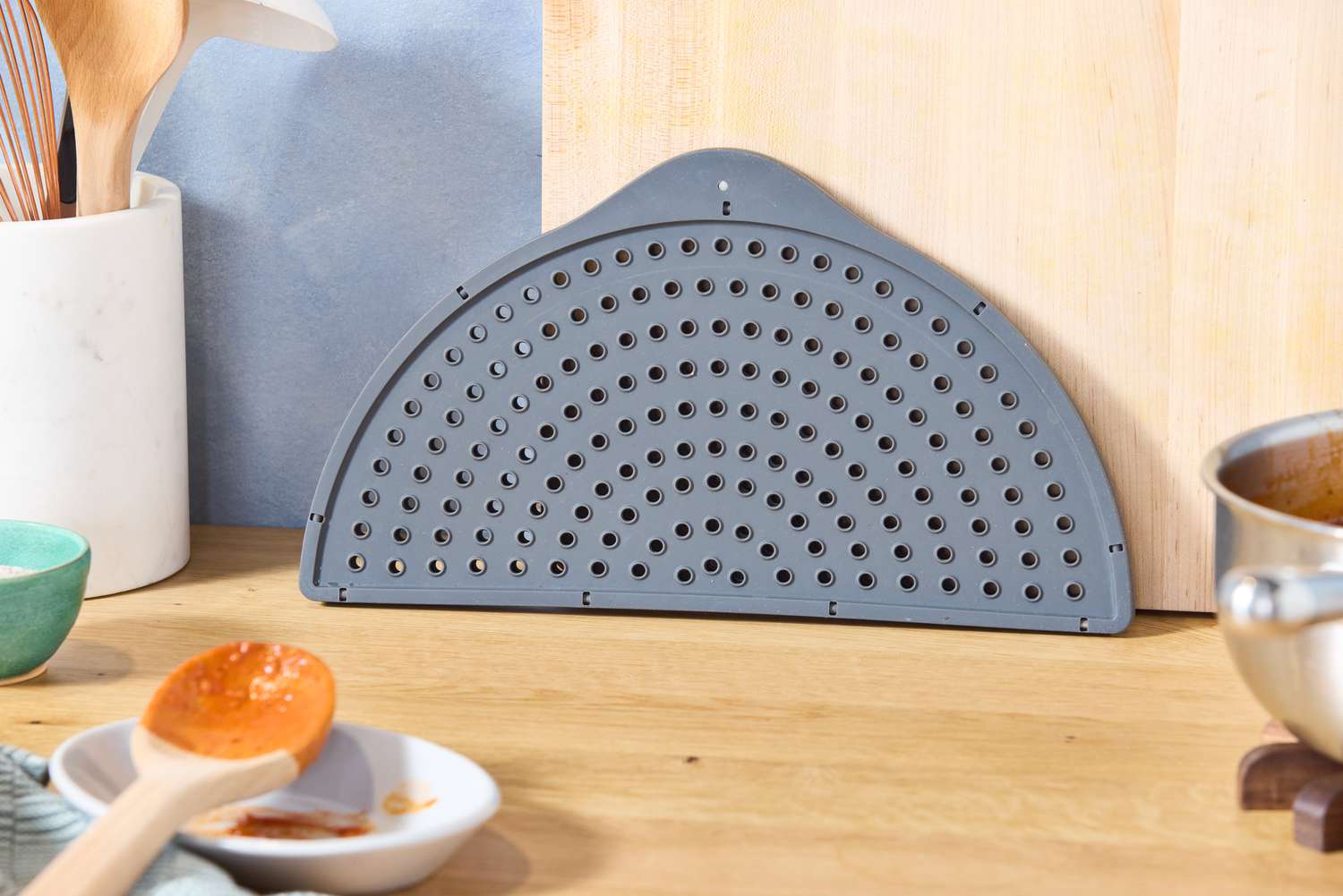 the williams sonoma splatter screen folded in half on a countertop
