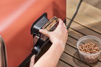 A hand removing part of the Ninja Woodfire 8-in-1 Outdoor Oven