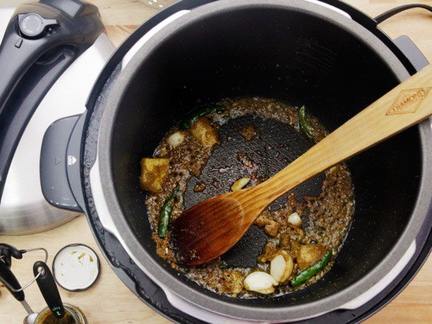 Frying aromatics in pressure cooker before adding additional ingredients for Thai green chicken curry.