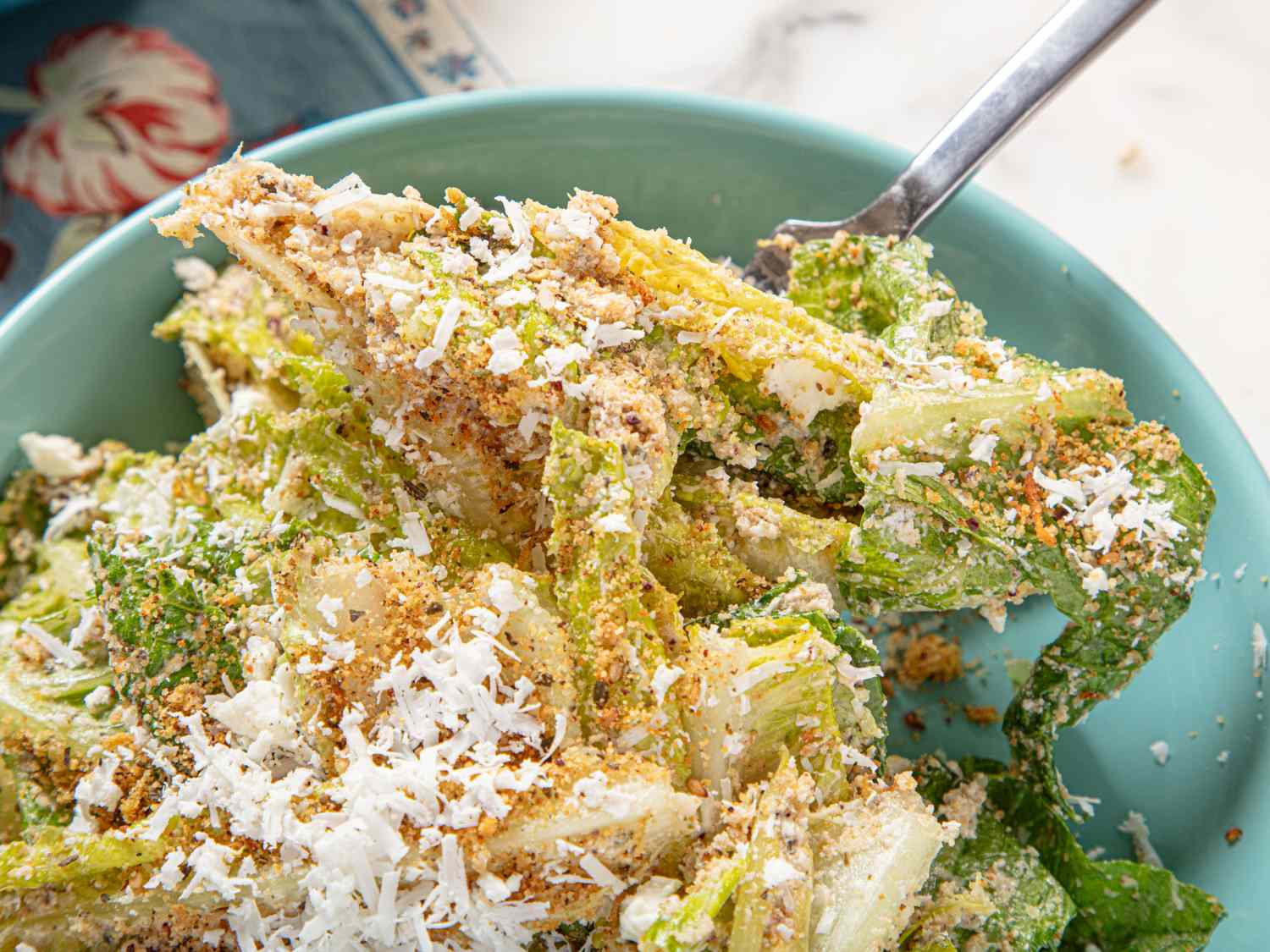A bowl of Caesar salad with feta zatar and grated cheese