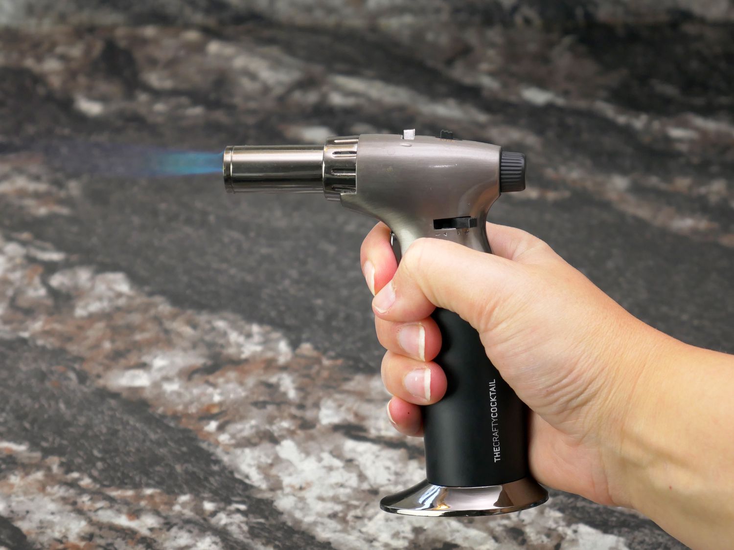 a person holding a lit butane torch