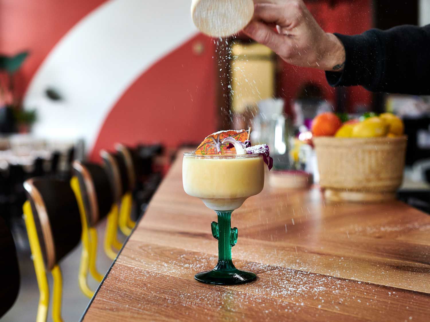 A finishing sprinkle is applied to a tropical drink at Eem