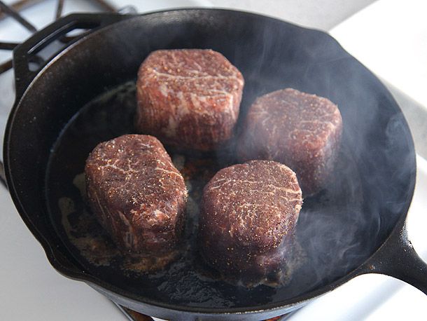Tenderloins that have been dry-aged varying amounts of time frying in a cast iron pan.