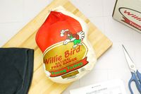 Packaged whole turkey labeled Willie Bird Natural Free Range Young Turkey on a wooden cutting board