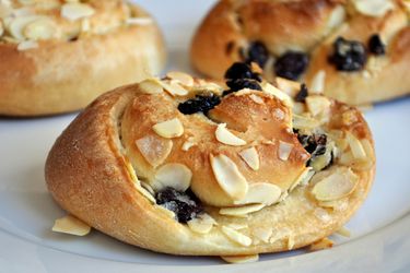 Closeup of cherry almond buns served on a white plate.