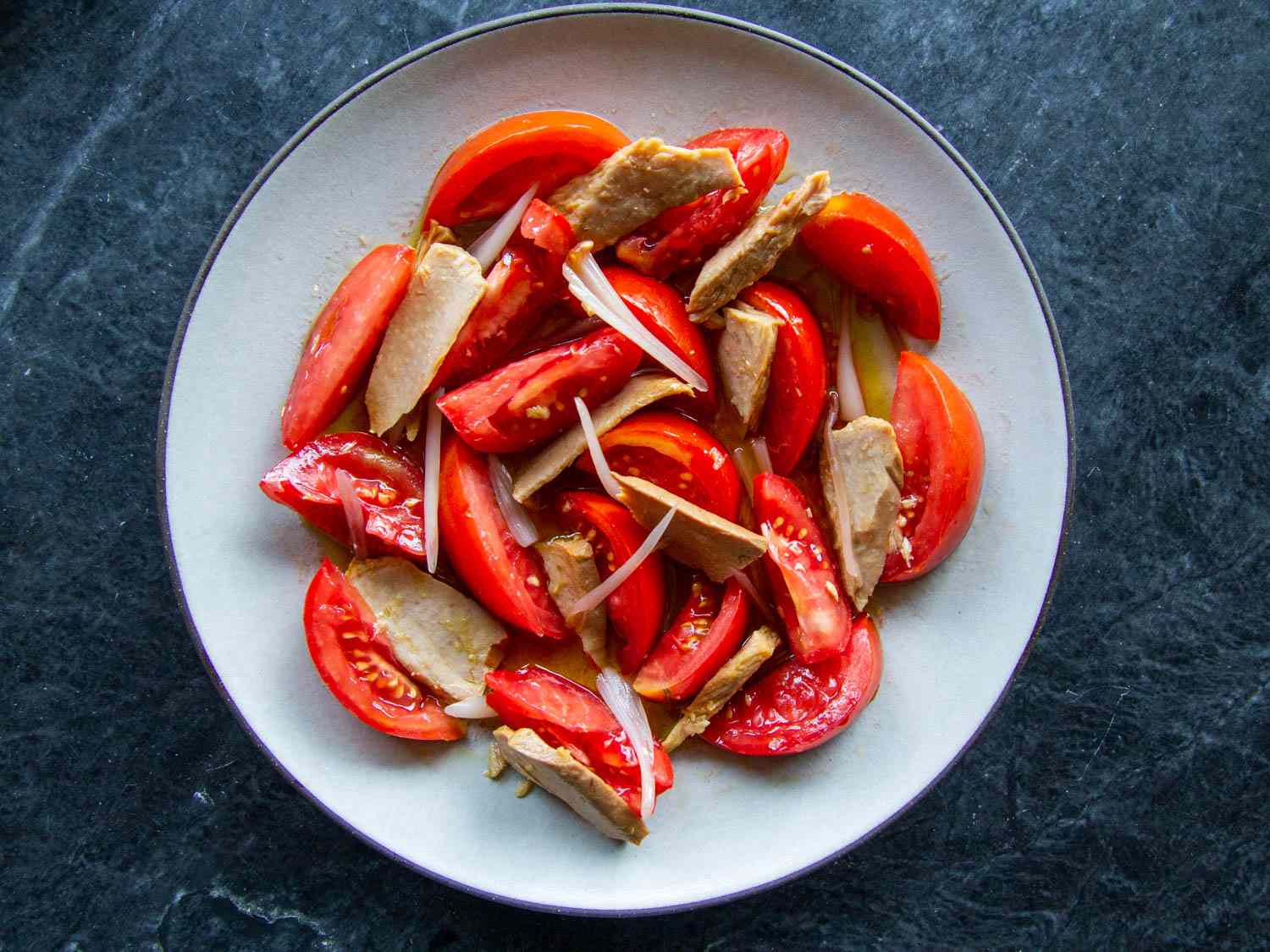 Overhead of a Spanish-style ripe tomato and olive-oil packed tuna salad. 