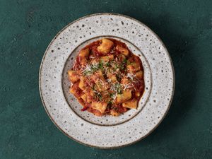 Ricotta gnocchi in tomato sauce on a ceramic plate.