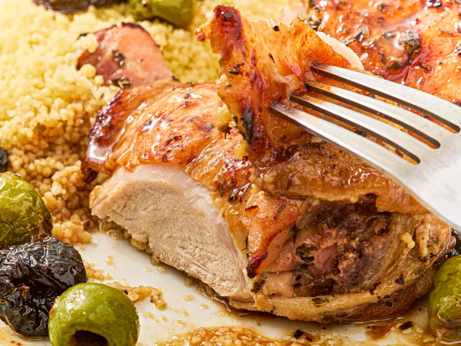 Sheet pan chicken marbella dish with olives and couscous closeup view