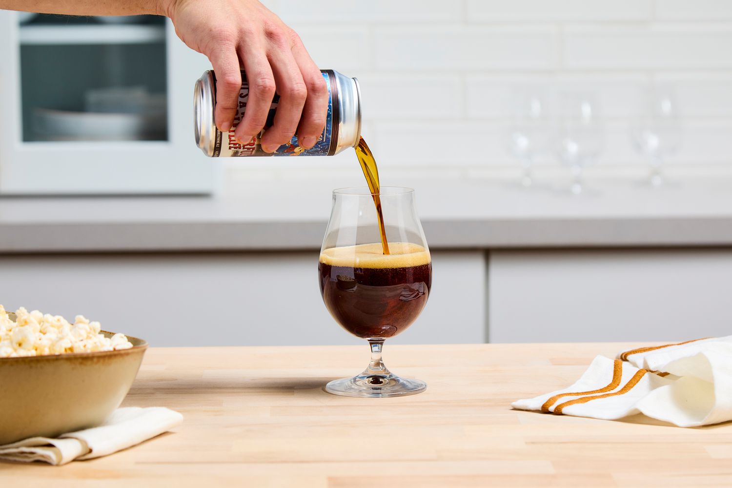 A person pouring beer into a glass.