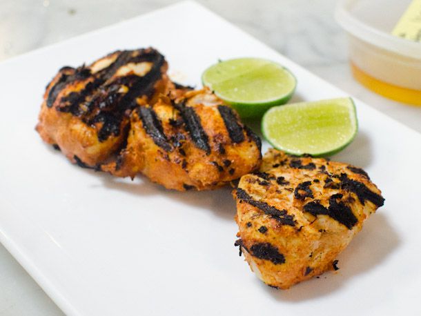Homemade chicken tikka on a plate with slices of fresh lime