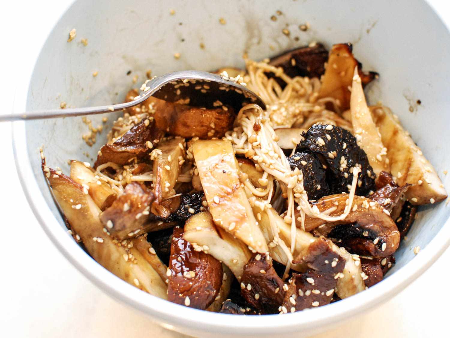 Tossing just grilled mushrooms with sesame seed mirin dressing.