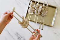 Threading shrimp onto metal skewers.