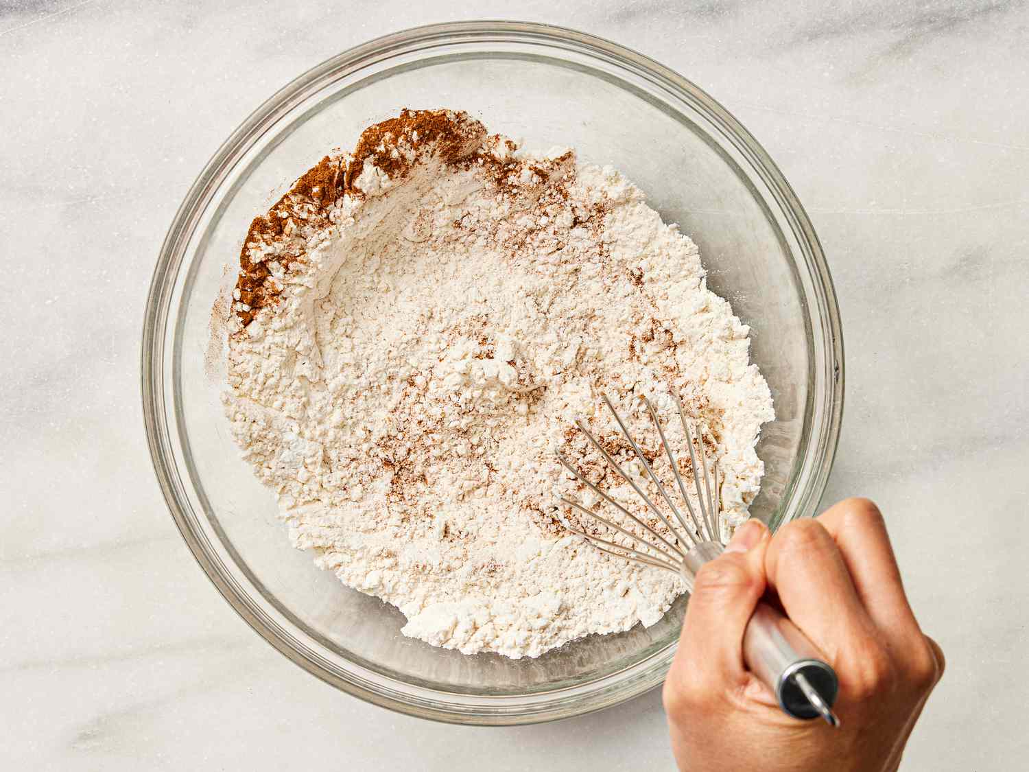 whisking flour mixture together in a glass bowl 