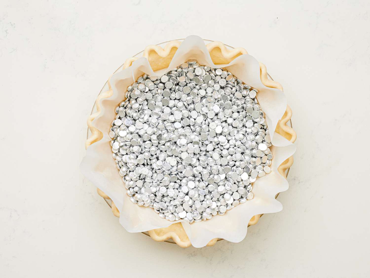 Overhead view of pie crust filled with pie weights