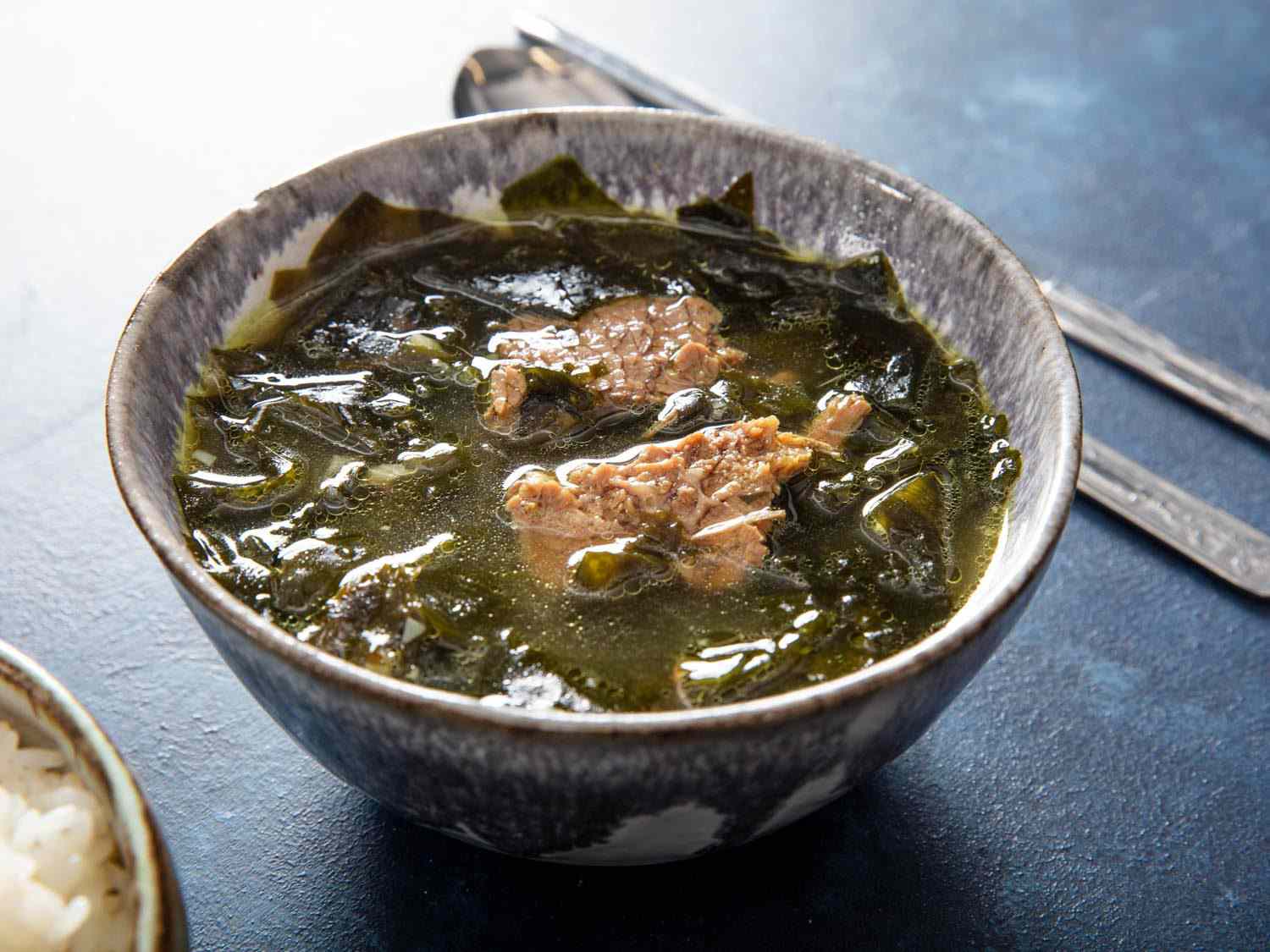 A bowl of Korean seaweed soup (miyeok guk) with pieces of brisket visible in the broth
