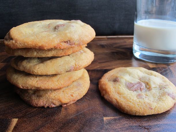 Chewy malted chocolate chip cookies, stacked next to a glass of milk.