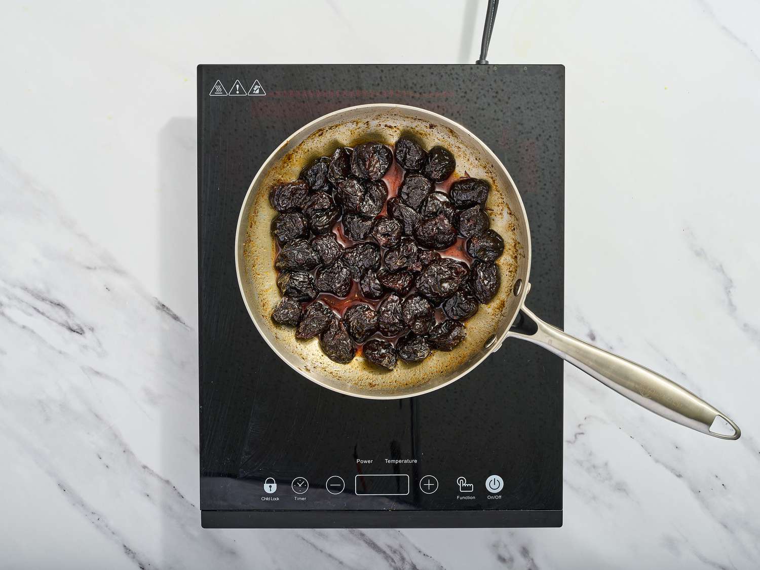 Prunes cooking in saucepan 