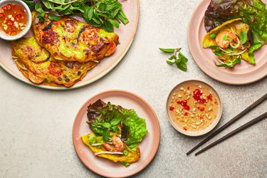 Overhead view of two servings of banh xeo and dipping sauce