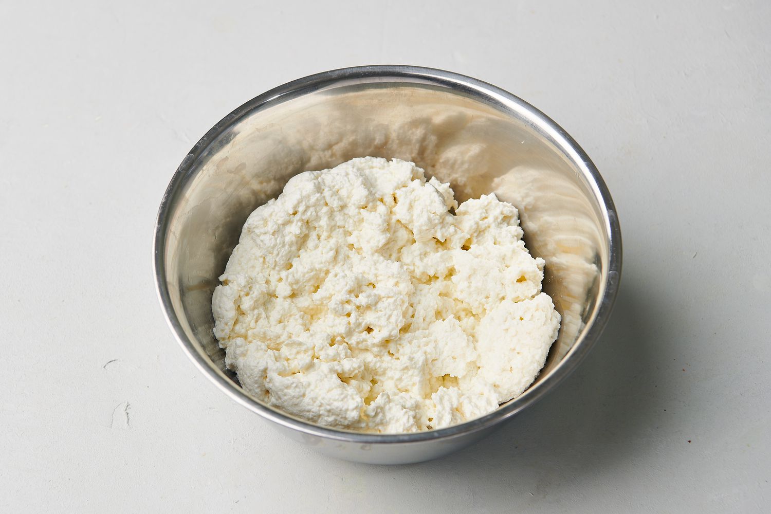 Homemade ricotta in a mixing bowl