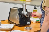 Person placing grinding plate to Weston #8 Electric Meat Grinder