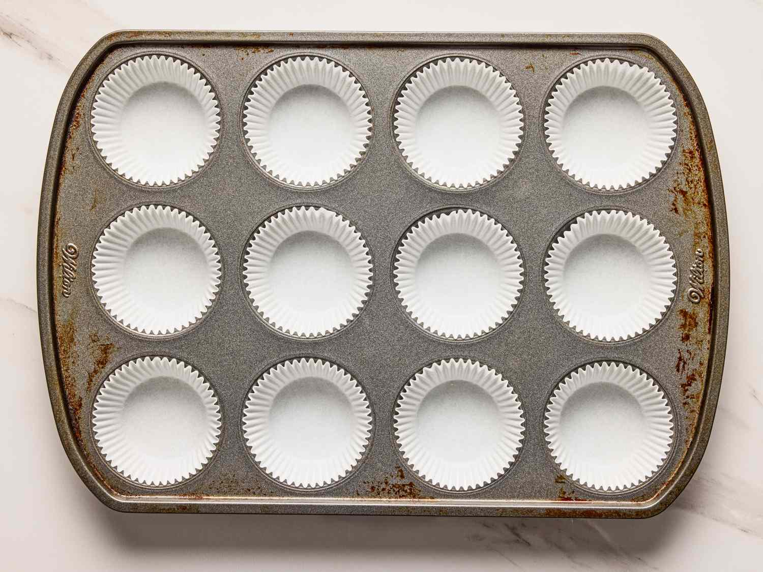 Muffin pan with paper liners placed in each cup