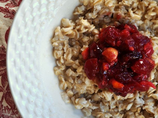 Overhead closeup of Oatmeal with Cranberry Orange Hazelnut Compote, served in a shallow white bowl.