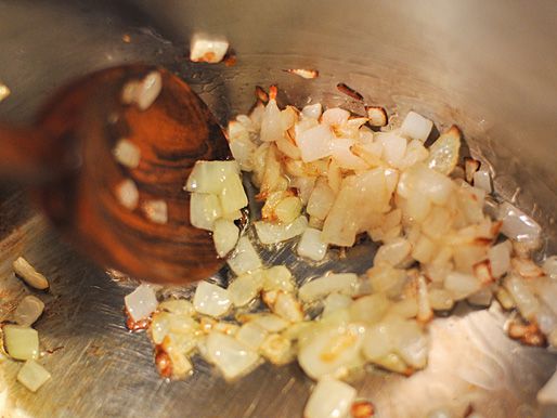 Chopped onion is sautéed in a saucepan.