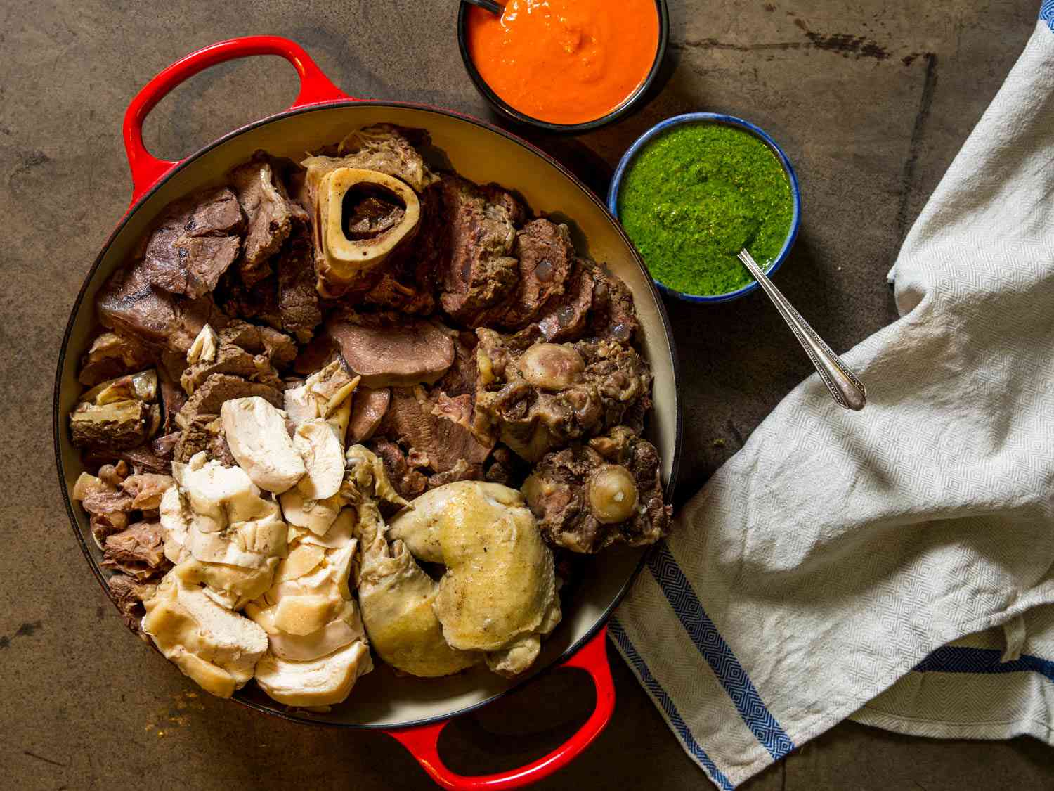 A large enamel cast iron Dutch oven with Bollito Misto (Italian Feast of Mixed Boiled Meats). 