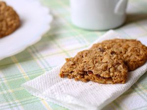 Gluten-free whole grain oatmeal cookies on a paper towel on a pastel plaid tablecloth.