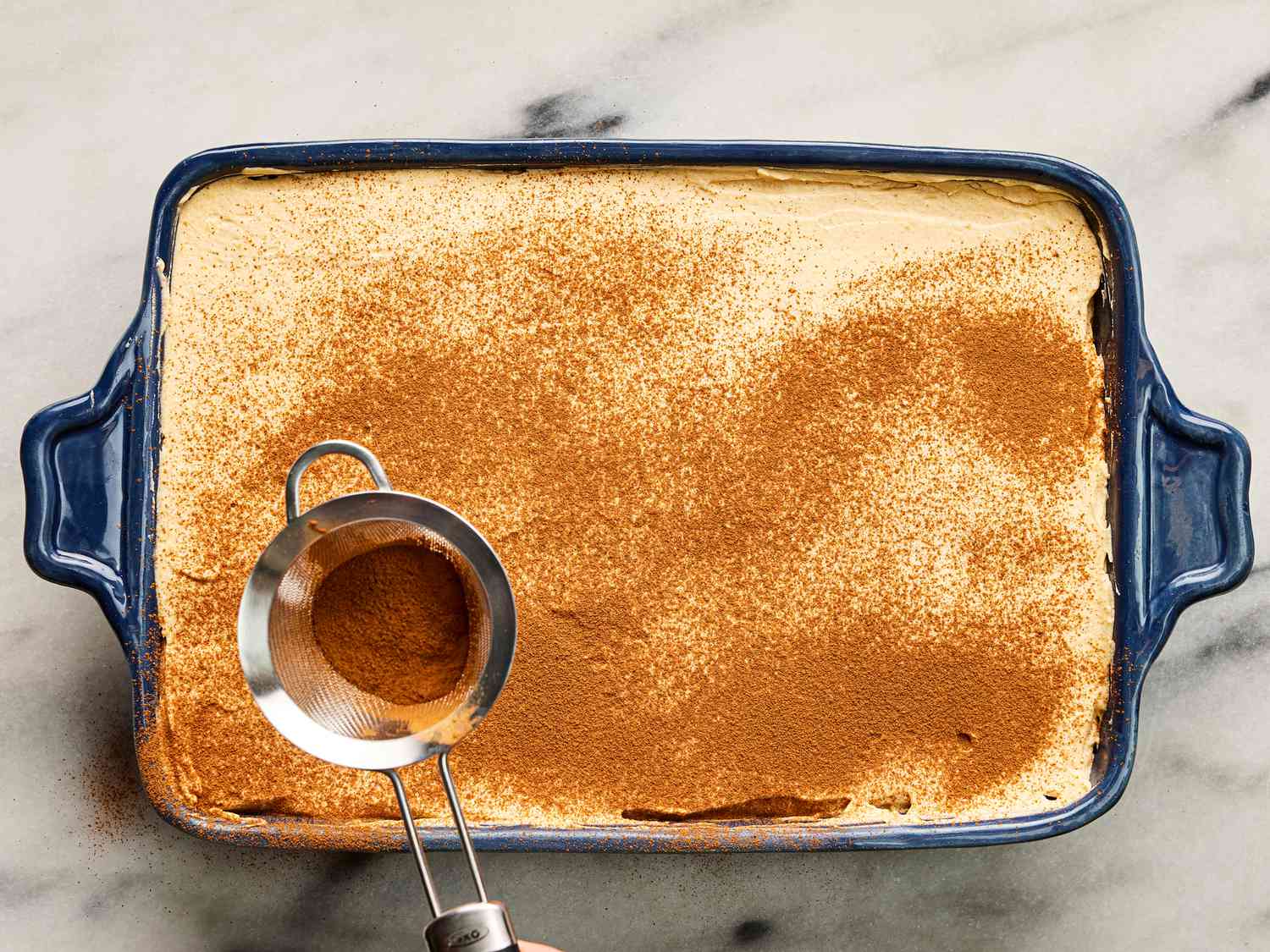 lightly dusting built tiramisu with espresso powder through a fine mesh sieve 