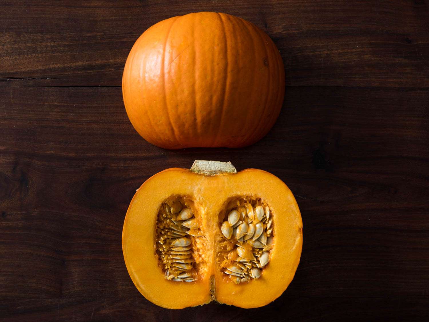 Sugar pumpkin halved and displayed cut side down and cut side up