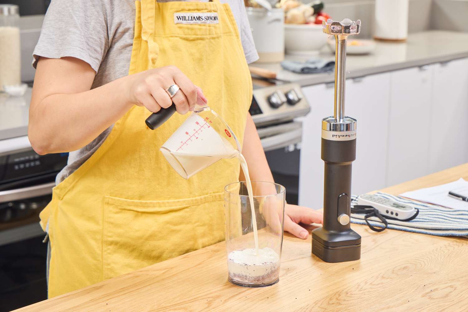 A person prepares to use the KitchenAid Go Cordless Hand Blender