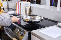 A person cooks using the Tramontina 12-Inch Stainless Steel Skillet