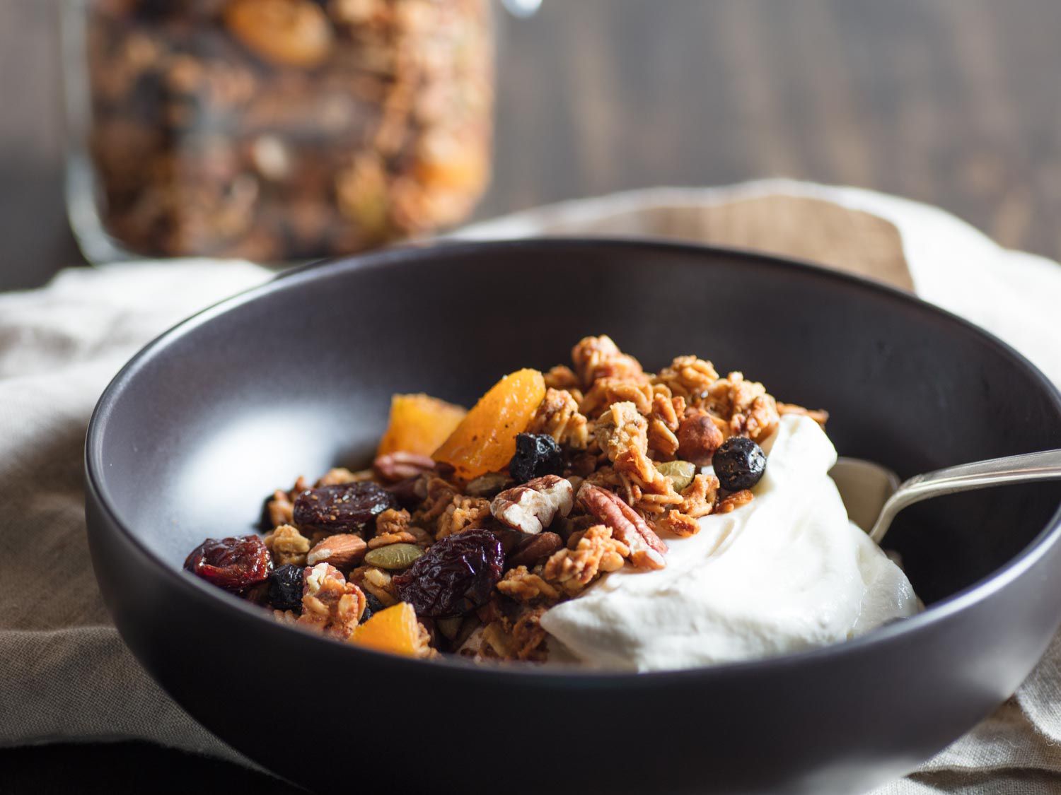 A bowl of granola and fruit with yogurt.