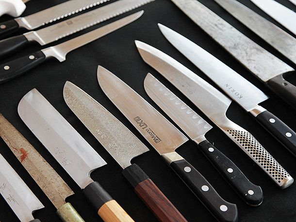 a collection of kenji's knives on a black countertop