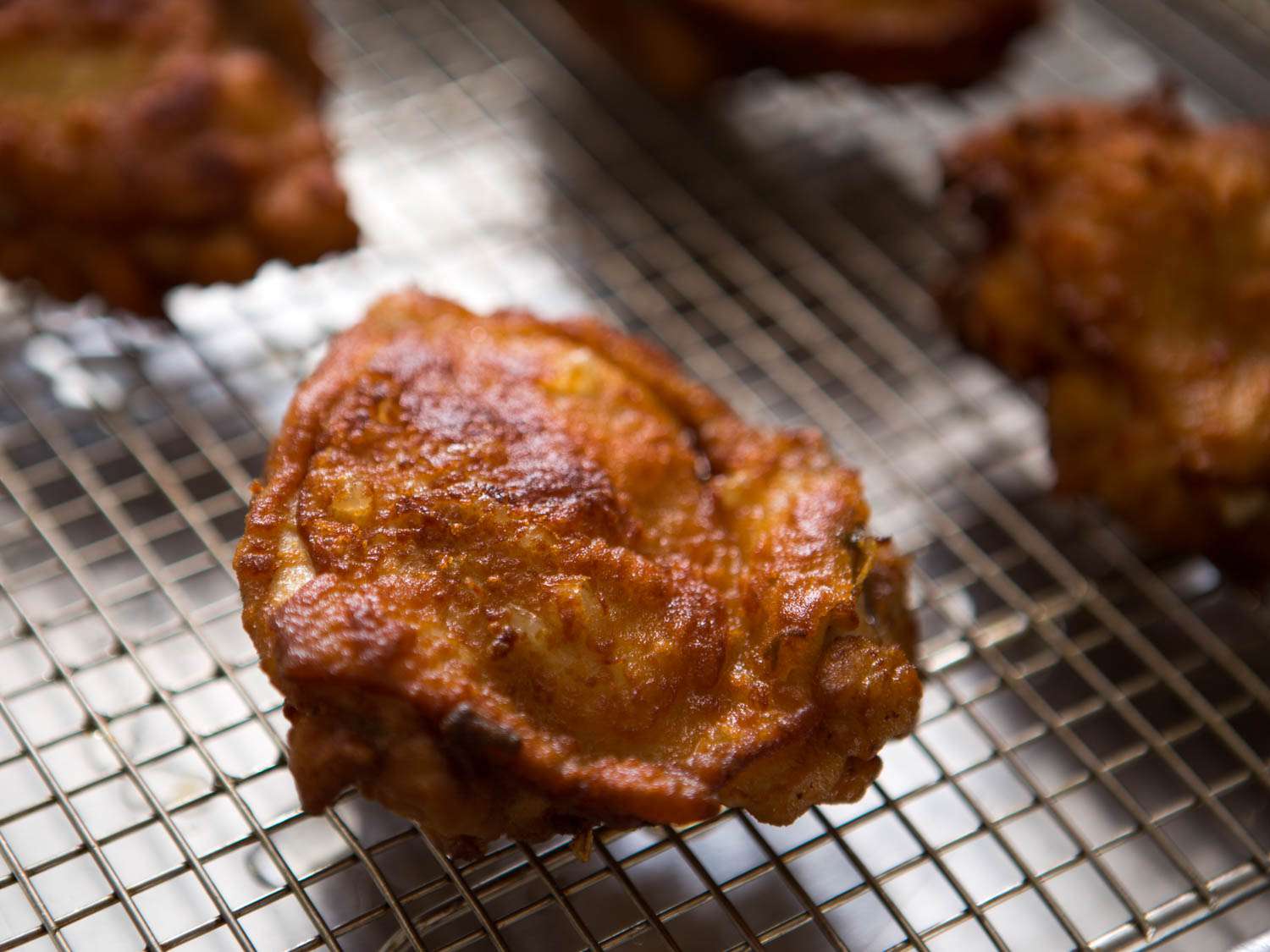Closeup of gluten-free Japanese-style fried chicken thighs set on a cooling rack.