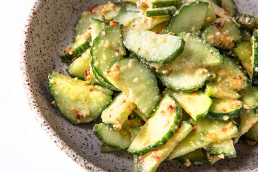 A bowl of cucumber salad tossed in mustard-oil dressing