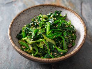 A small earthenware bowl of Korean marinated spinach.