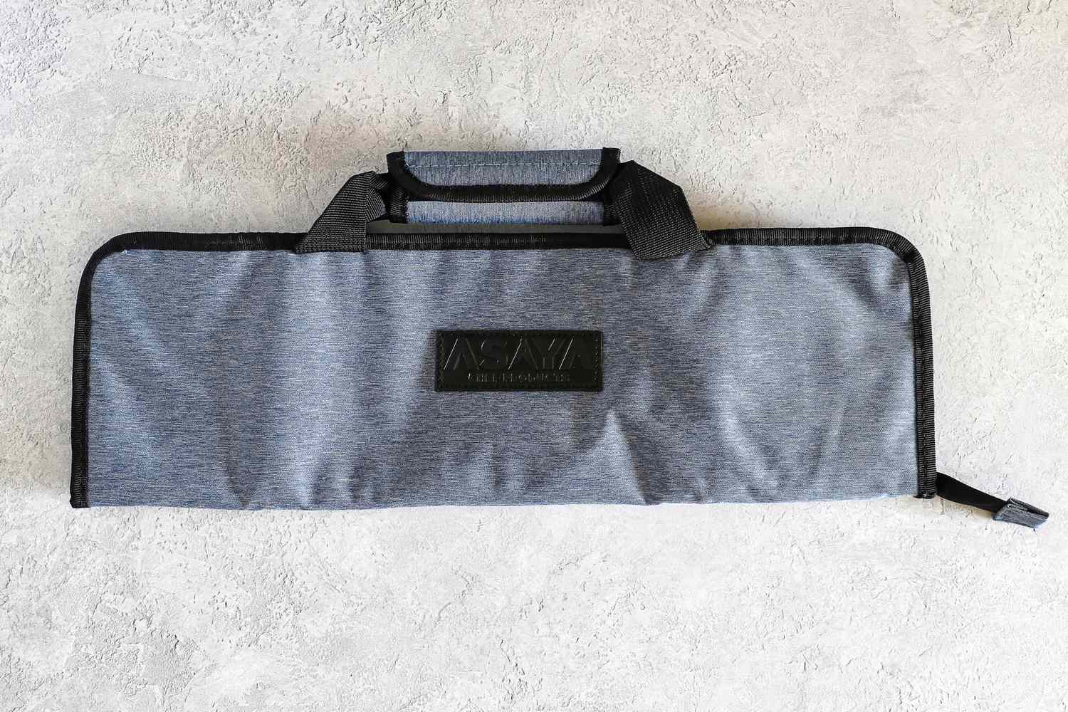 Asaya Chef Knife Roll Bag with black handles and a visible Asaya brand logo on the front