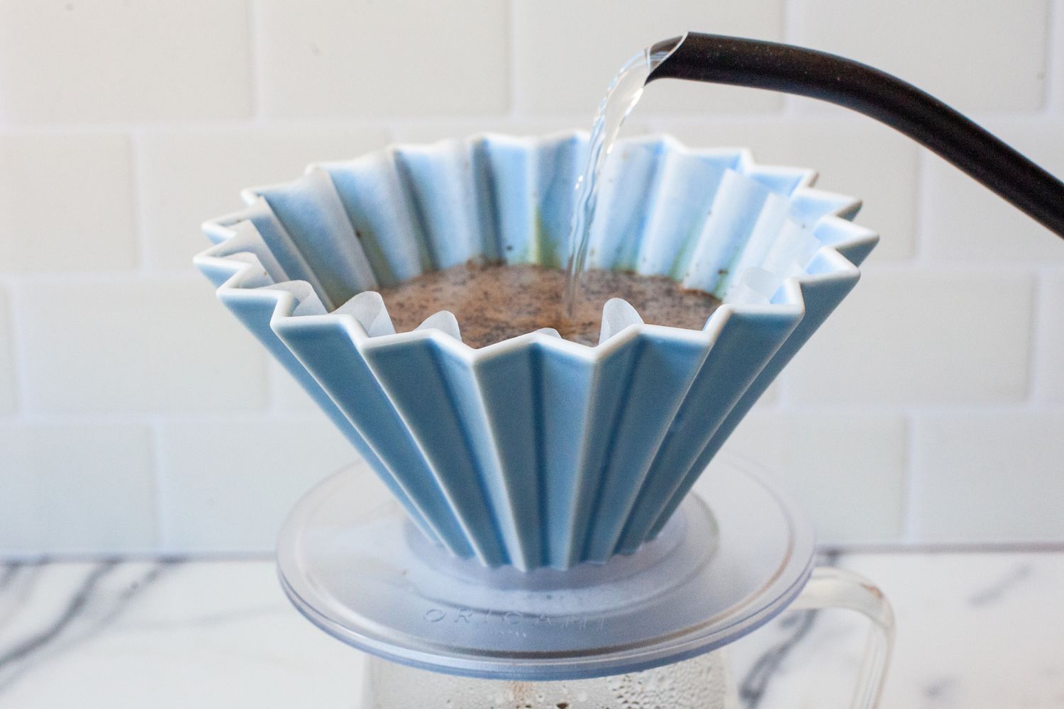 A kettle pouring water into the Origami dripper