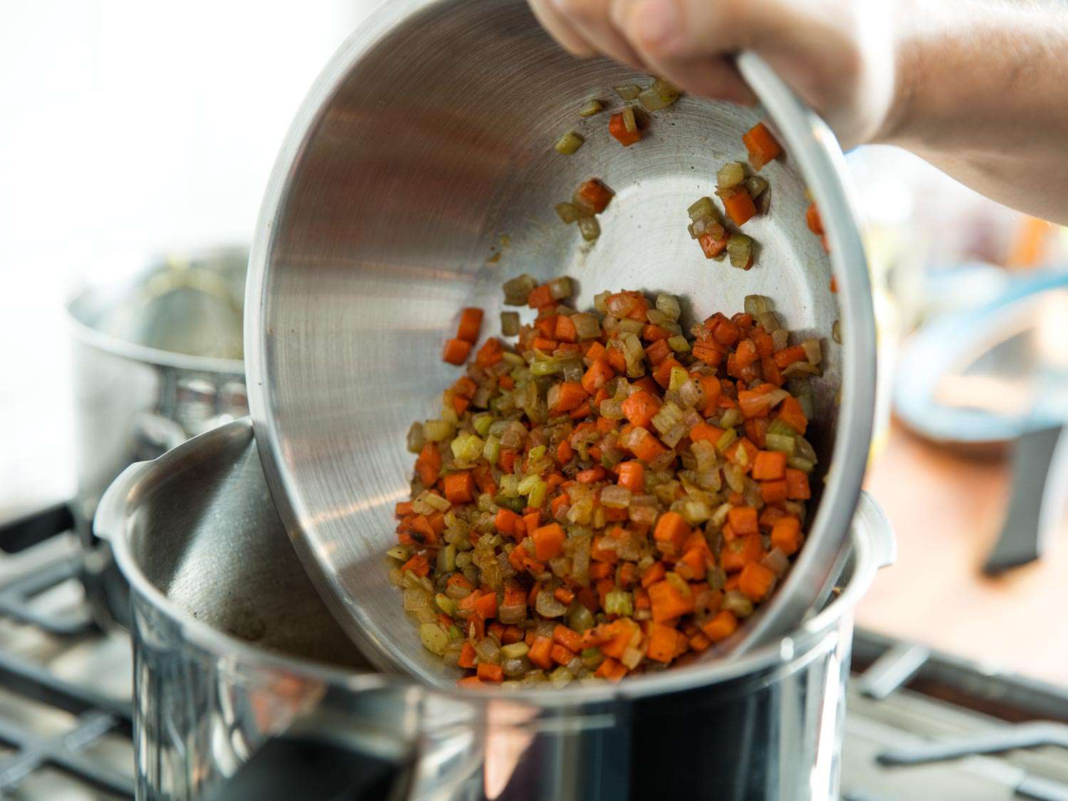 Adding diced vegetables to pressure cooker.