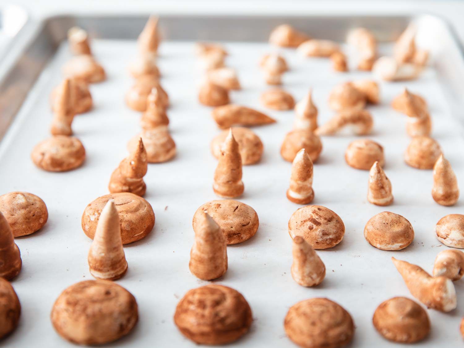 Detail shot of meringue mushroom caps and stems sorted for assembly.