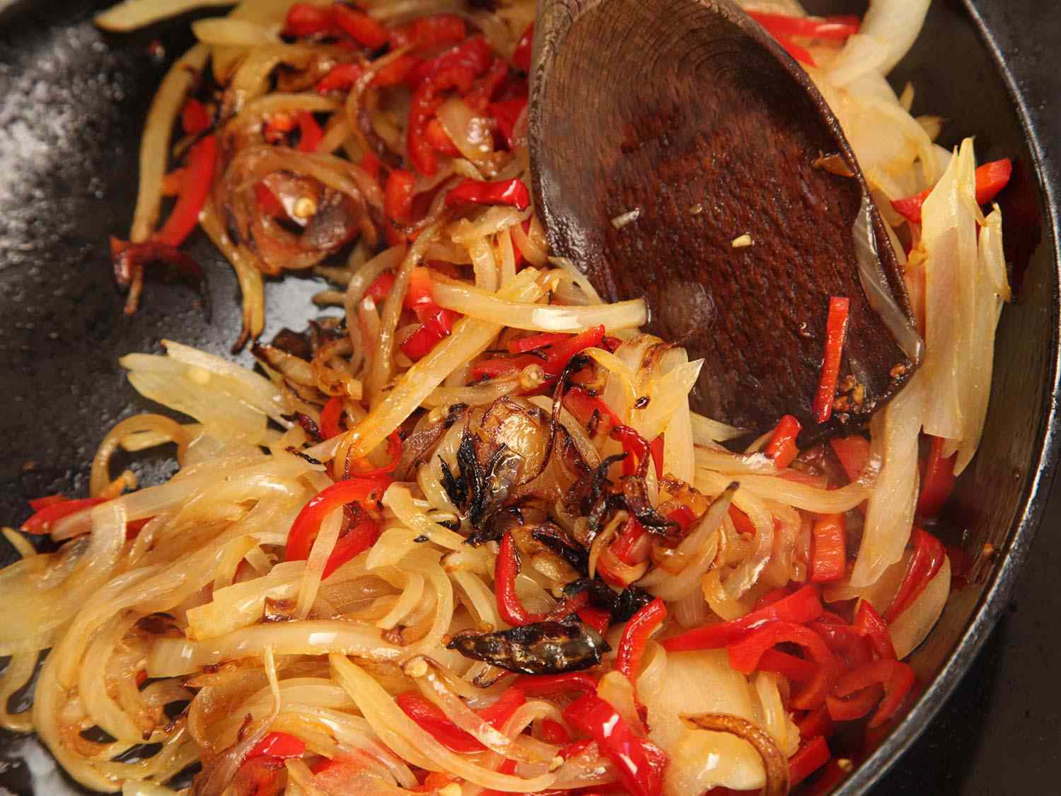 Cooking onions and peppers until charred for shakshuka.