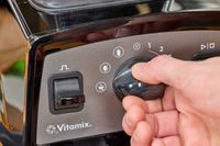 A close-up of a hand turning a nob on the Vitamix Propel 510