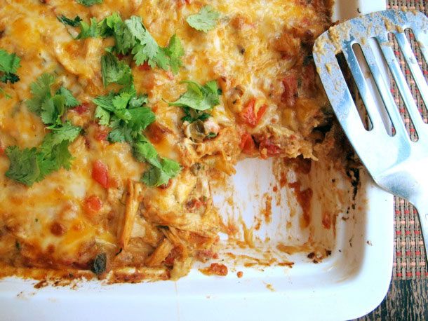 A close up of a spatula and a dish of King Ranch casserole, with a serving missing.