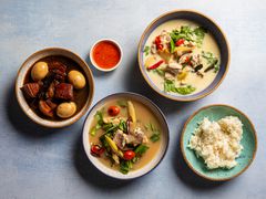 Overhead view of three thai soups with rice and dipping sauce 