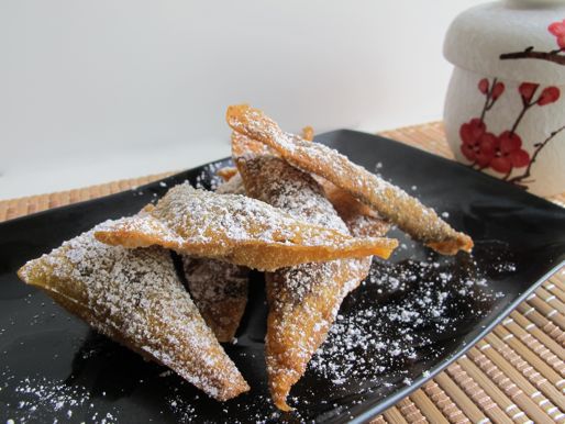 A pile of crunchy fried chocolate wontons, dusted with five-spice sugar.