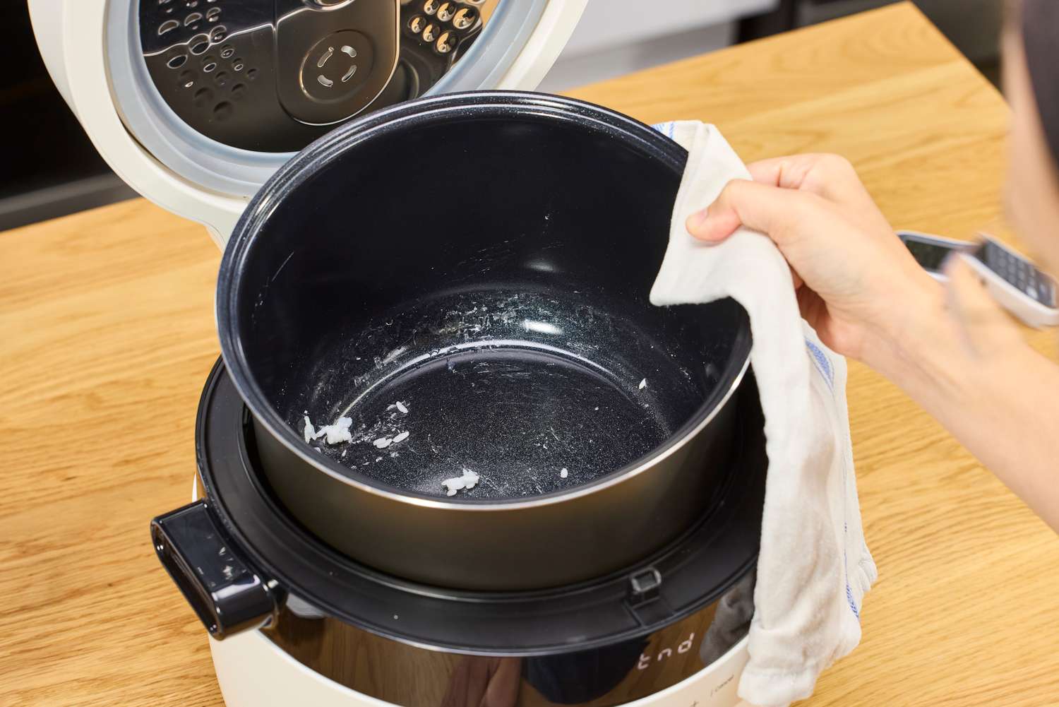 A lifts the bowl from the Instant Pot 20 Cup Multigrain Cooker