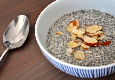 Closeup of coconut almond chia seed pudding, served in a small bowl with a garnish of slivered almonds.